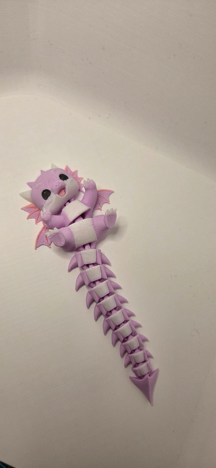 Full view of pink lilac and white 3D printed articulated baby dragon