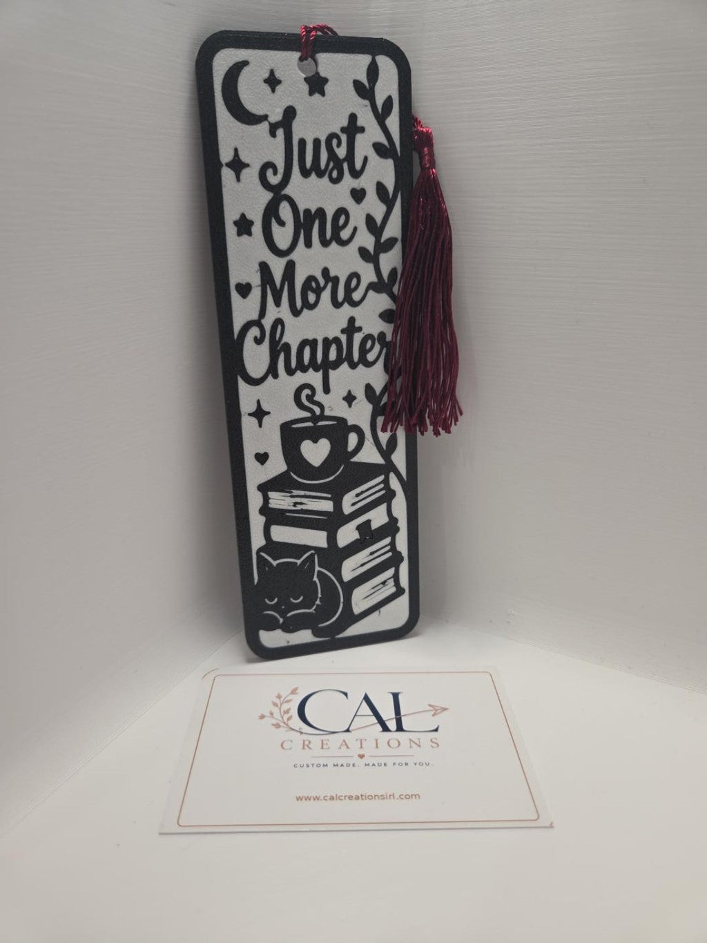 Just One More Chapter bookmark with burgundy tassel hanging to the side