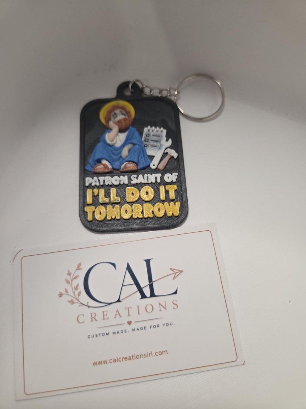 Patron Saint of I'll Do It Tomorrow funny keyring with metal keyring attachment, front view