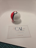 Angled view of red white and black Poké Ball clicker