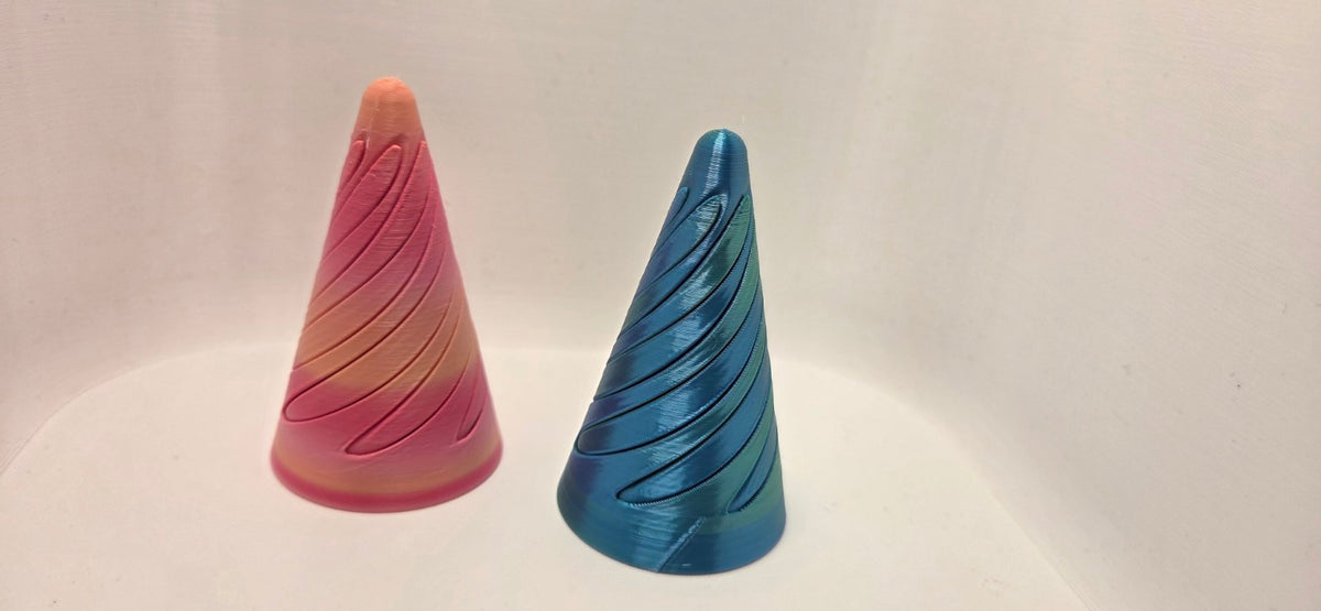 Two 3D printed spiral cone fidgets in Pink Gradient and Blue/Green Metallic Silk